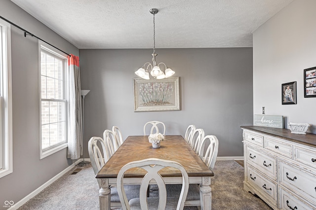 dining area featuring an inviting chandelier, dark carpet, and a textured ceiling