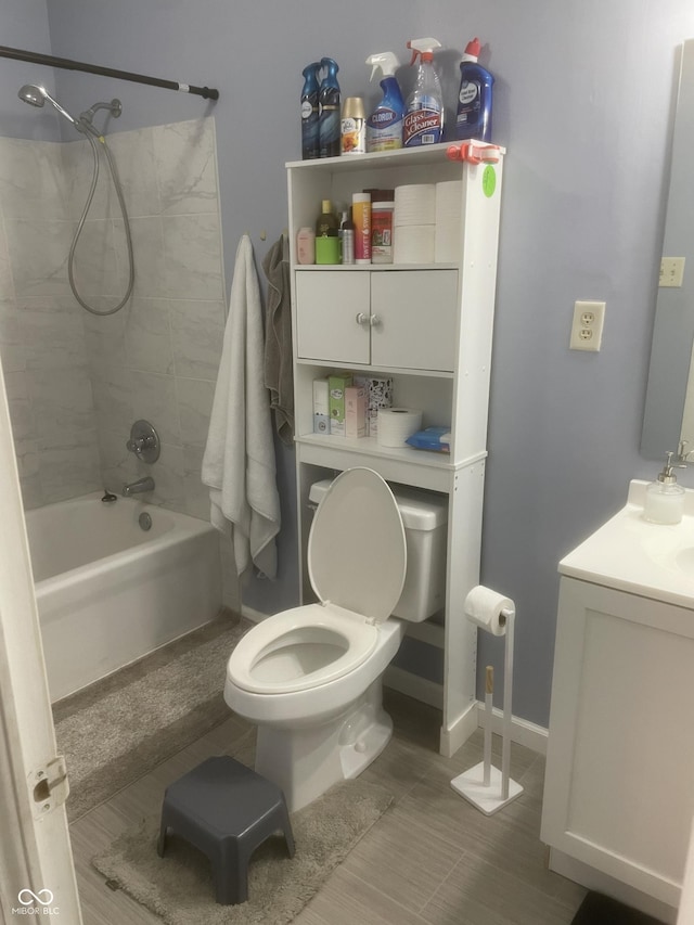 full bathroom with vanity, tiled shower / bath combo, and toilet