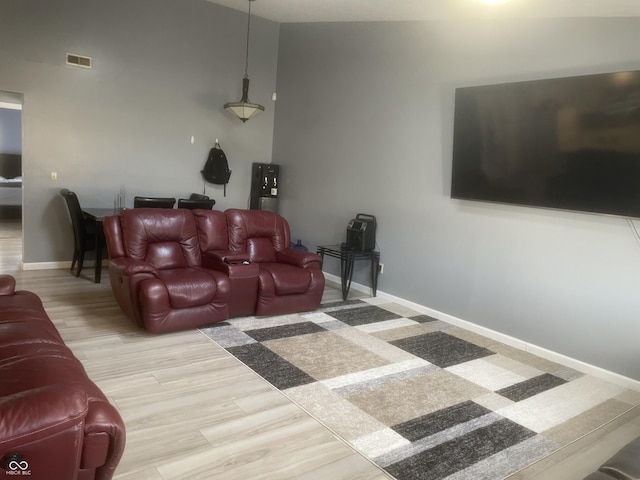 living room with light hardwood / wood-style floors and a high ceiling