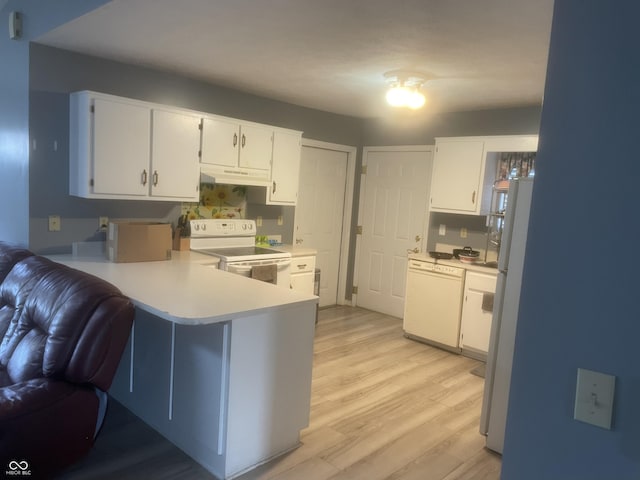 kitchen with kitchen peninsula, white cabinets, white appliances, and light hardwood / wood-style flooring