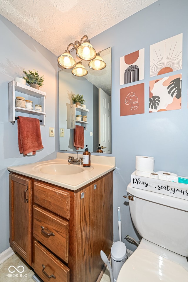 bathroom featuring vanity, toilet, and a textured ceiling