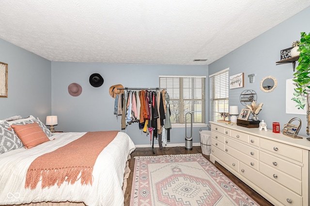 bedroom with dark hardwood / wood-style floors and a textured ceiling