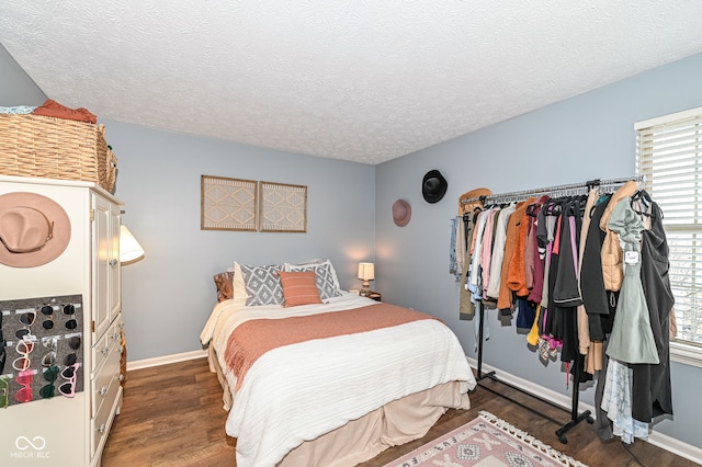 bedroom with dark hardwood / wood-style floors and a textured ceiling