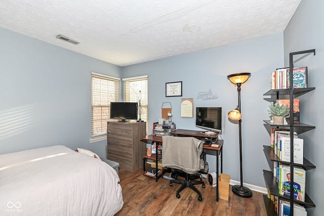 bedroom featuring hardwood / wood-style flooring and a textured ceiling