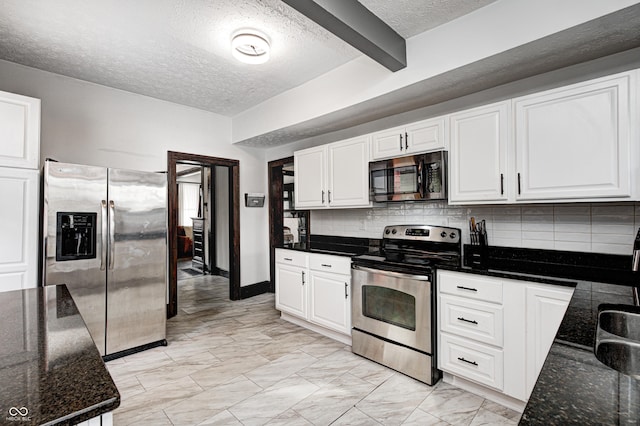 kitchen with stainless steel appliances, decorative backsplash, white cabinets, and dark stone counters