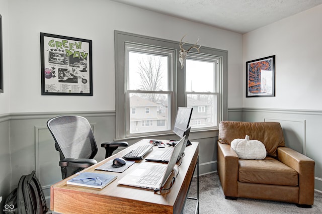 carpeted office featuring a textured ceiling