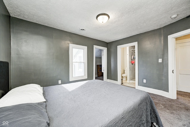 bedroom with connected bathroom, a textured ceiling, and carpet