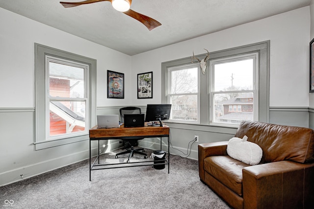 carpeted office with ceiling fan and a textured ceiling