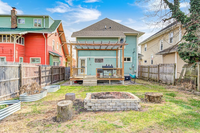 back of house featuring a pergola, a fire pit, a lawn, and a deck