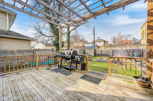 wooden terrace featuring a grill, a yard, a shed, and a pergola