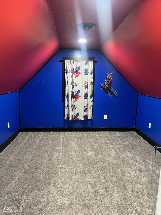 bonus room with carpet flooring and vaulted ceiling