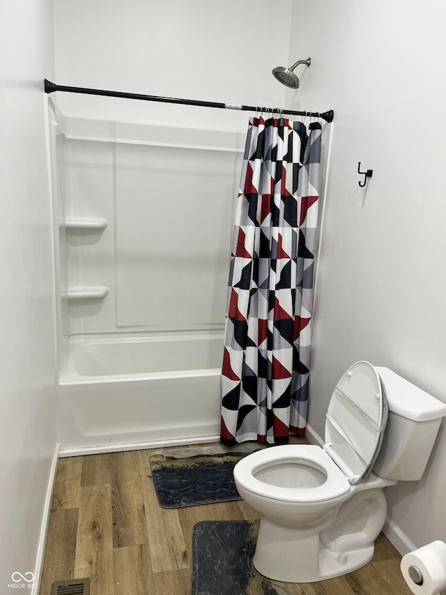 bathroom featuring toilet, wood-type flooring, and shower / bathtub combination with curtain