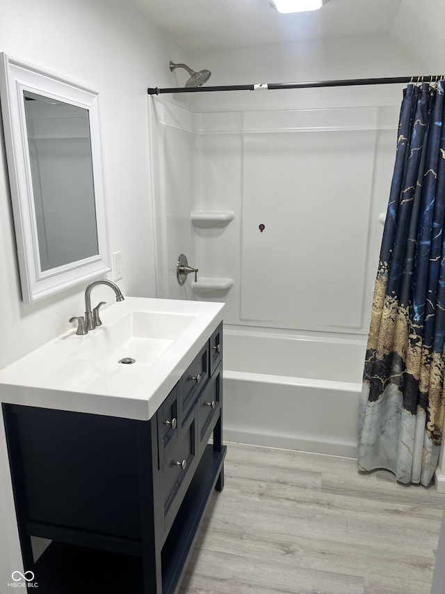 bathroom with hardwood / wood-style flooring, vanity, and shower / bath combo with shower curtain