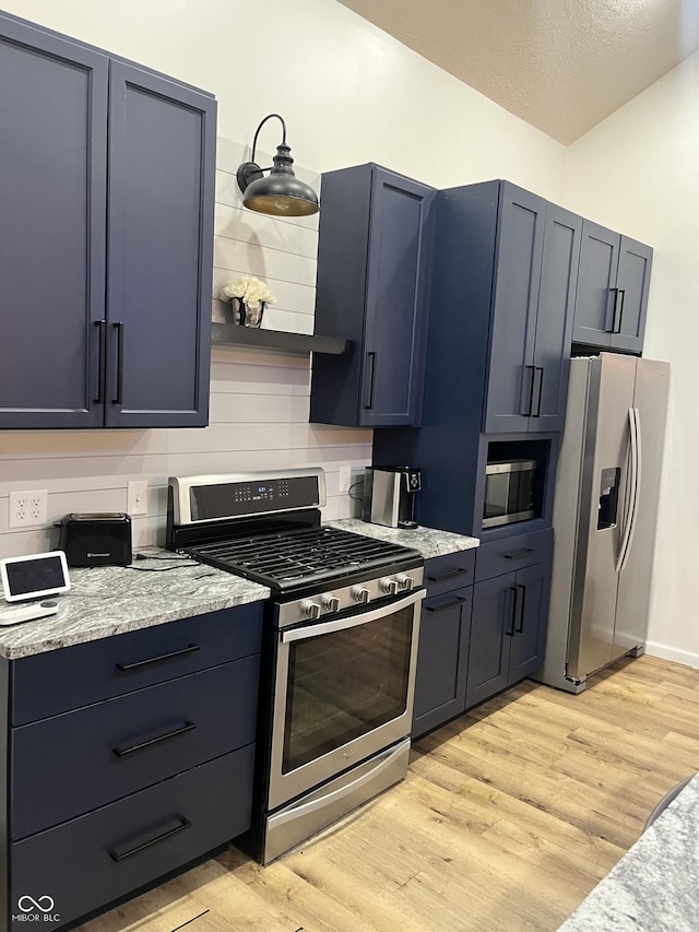 kitchen featuring stainless steel appliances, light stone countertops, and light hardwood / wood-style flooring