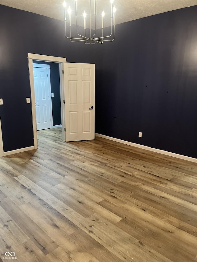 unfurnished dining area with hardwood / wood-style flooring and a chandelier