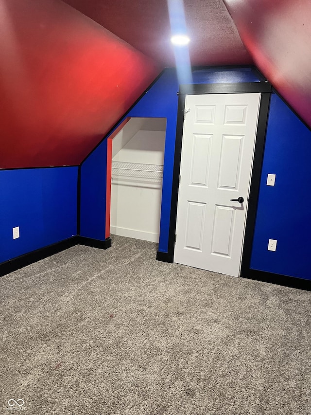 additional living space with lofted ceiling, carpet flooring, and a textured ceiling