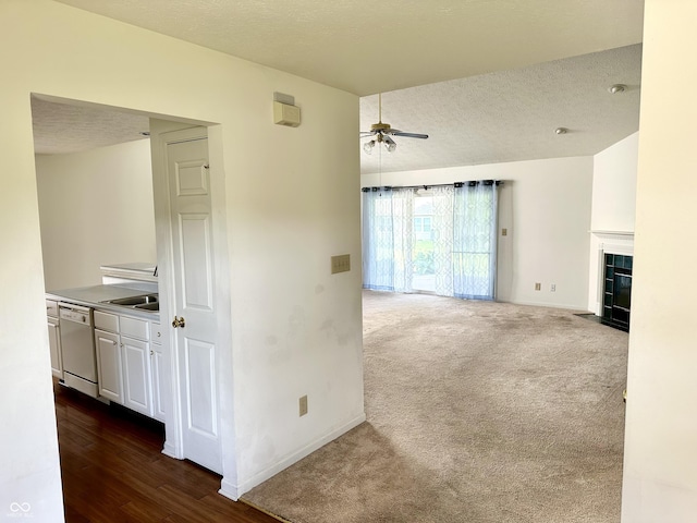 1348 Mccormicks Cir, Danville, IN 46122 - unfurnished living room with a ceiling fan, baseboards, a tile fireplace, a textured ceiling, and dark colored carpet
