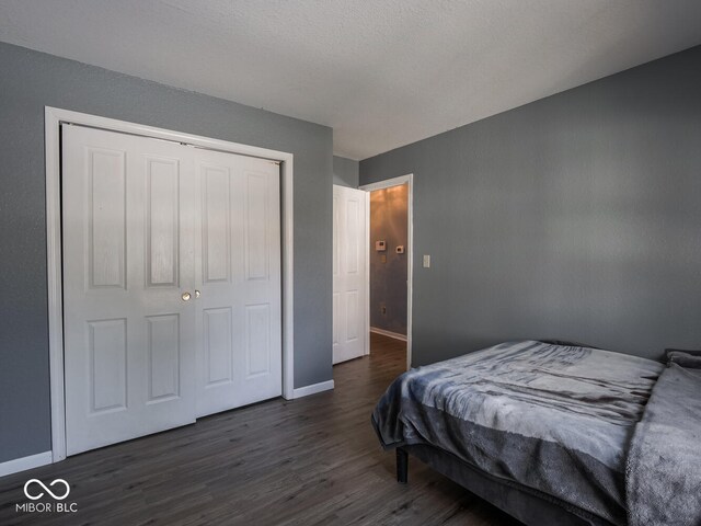 6264 Whitaker Farms Dr, Indianapolis, IN 46237 - bedroom featuring dark hardwood / wood-style flooring, a closet, and a textured ceiling