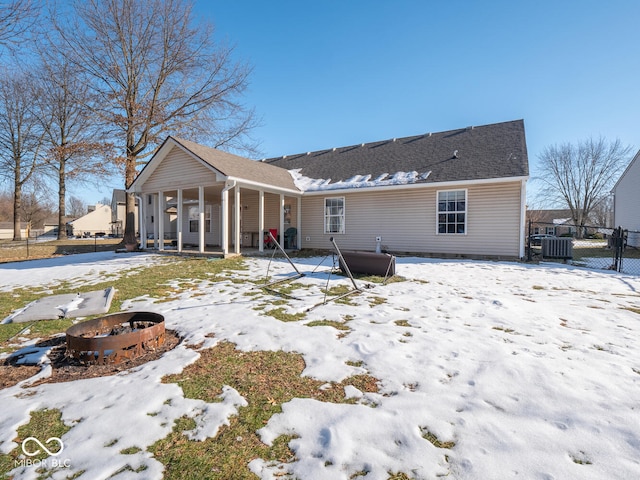 6264 Whitaker Farms Dr, Indianapolis, IN 46237 - snow covered back of property featuring an outdoor fire pit, central AC unit, and covered porch