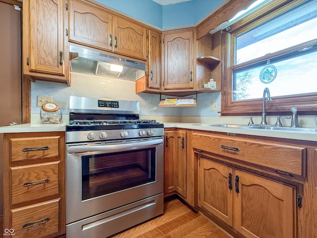 kitchen with sink, backsplash, and stainless steel gas range oven