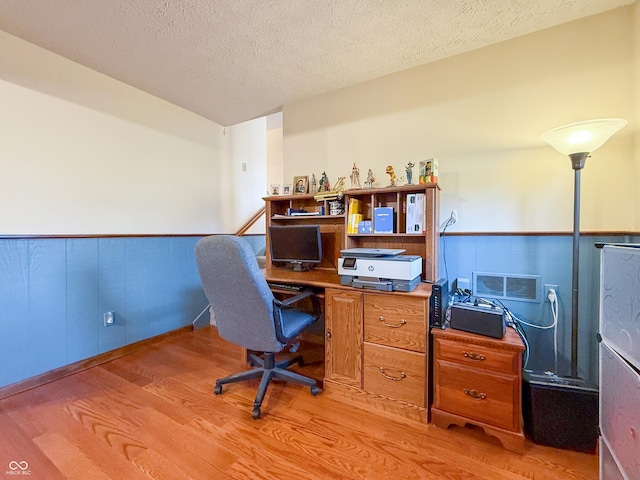 office space featuring a textured ceiling and light hardwood / wood-style flooring