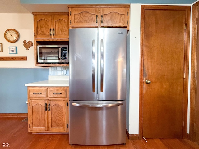 kitchen featuring appliances with stainless steel finishes and light hardwood / wood-style flooring