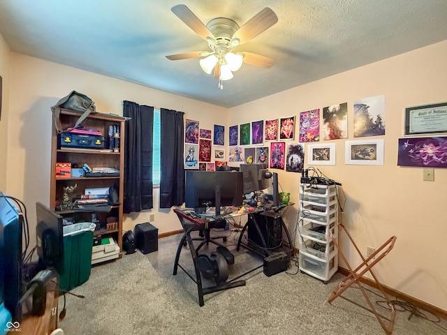 carpeted home office with a textured ceiling and ceiling fan