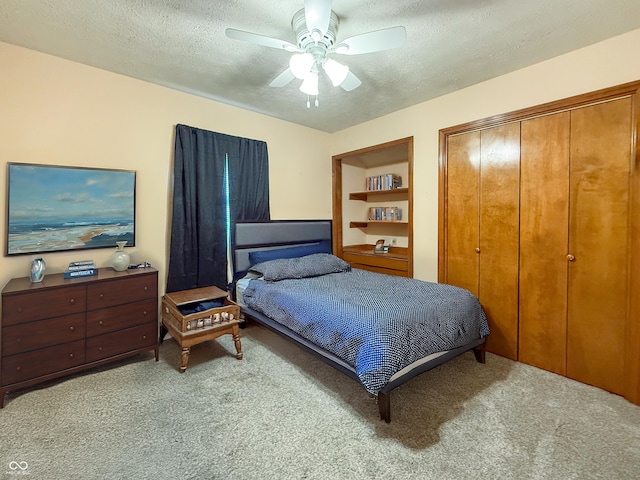 carpeted bedroom with ceiling fan, a textured ceiling, and a closet