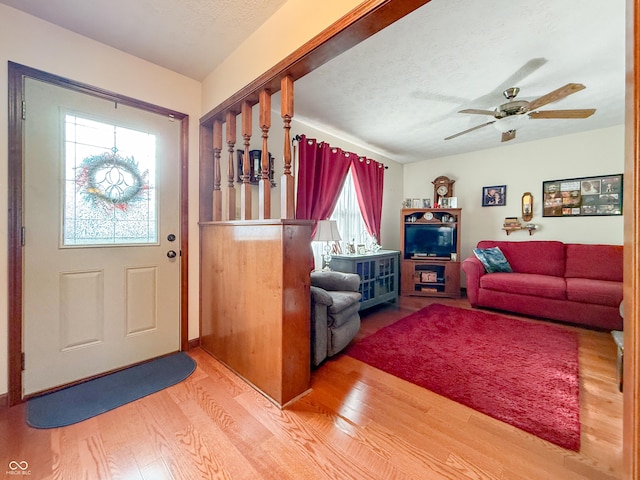 living room featuring hardwood / wood-style floors, a textured ceiling, and ceiling fan