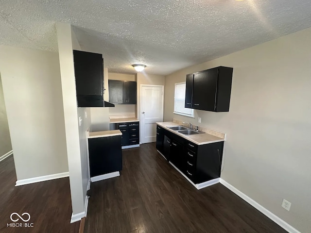 kitchen featuring sink, dark wood-type flooring, and a textured ceiling