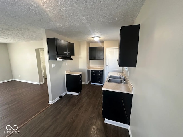 kitchen featuring sink, a textured ceiling, and dark hardwood / wood-style floors