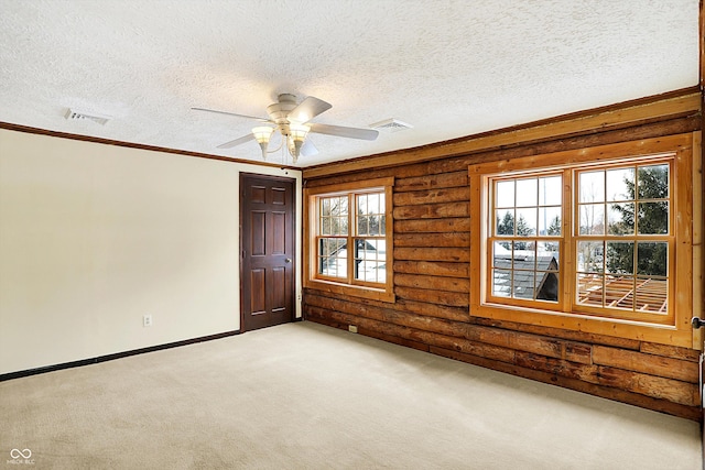 empty room with baseboards, visible vents, carpet, and a textured ceiling