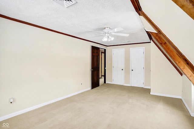 interior space featuring visible vents, baseboards, crown molding, light colored carpet, and a textured ceiling