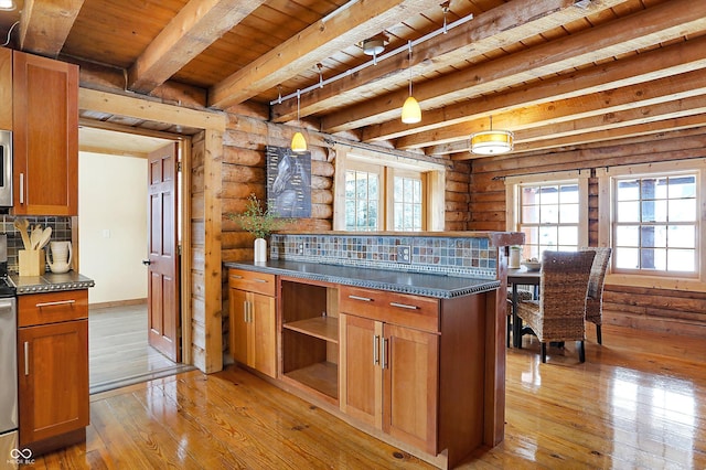 kitchen with log walls, decorative light fixtures, light wood-type flooring, dark countertops, and brown cabinetry