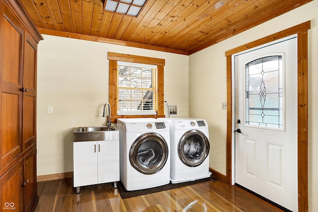 washroom with a sink, wooden ceiling, dark wood-type flooring, cabinet space, and washer and clothes dryer