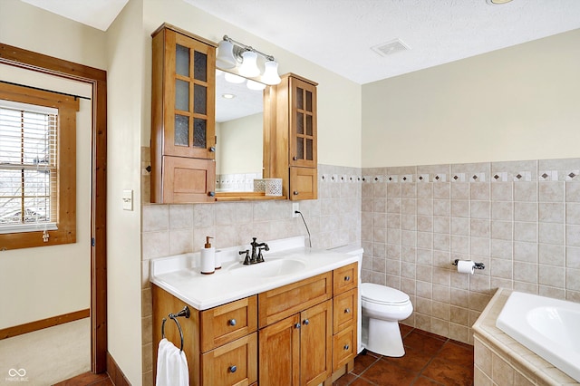 full bathroom with visible vents, a bath, tile walls, and vanity