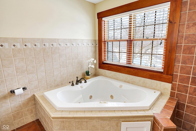 bathroom featuring a tub with jets and tile walls