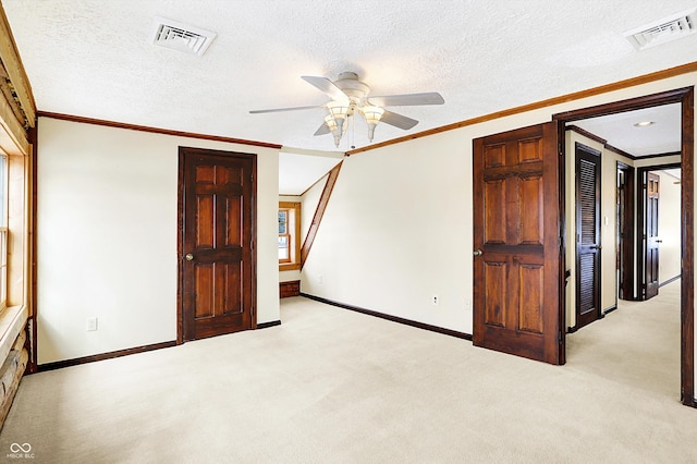 unfurnished bedroom with visible vents, crown molding, and light colored carpet