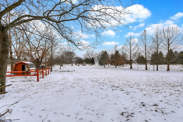 yard layered in snow with a storage shed