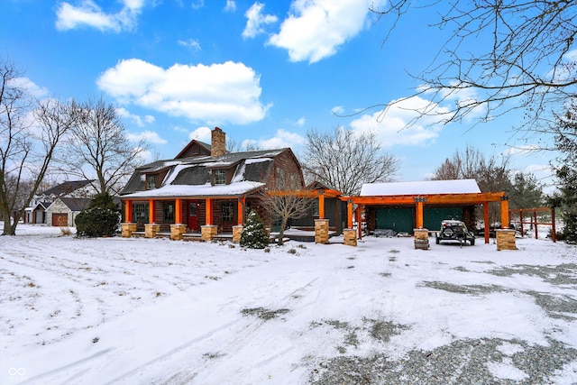 view of front of property featuring a gambrel roof, a porch, and a chimney