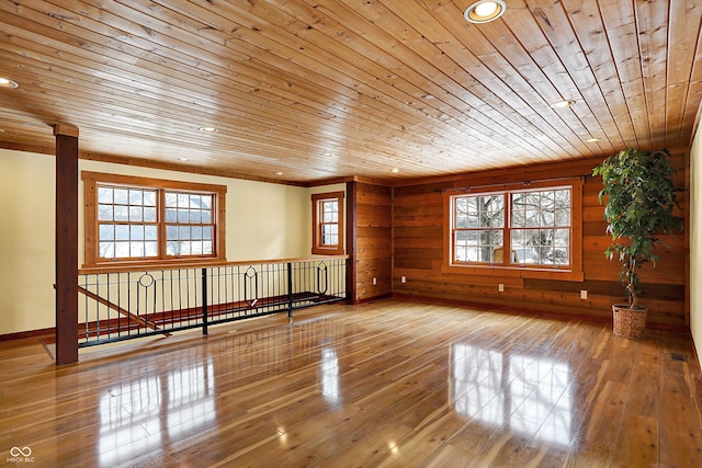 empty room featuring wooden ceiling, plenty of natural light, and wood finished floors