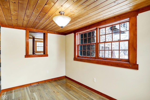 spare room with light wood-type flooring, wood ceiling, and baseboards