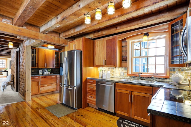 kitchen featuring a sink, dark countertops, brown cabinets, and stainless steel appliances