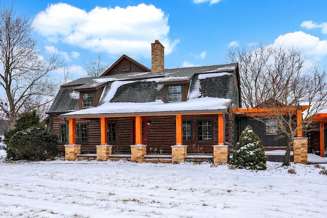 view of front of property featuring a porch, a chimney, a shingled roof, and a gambrel roof