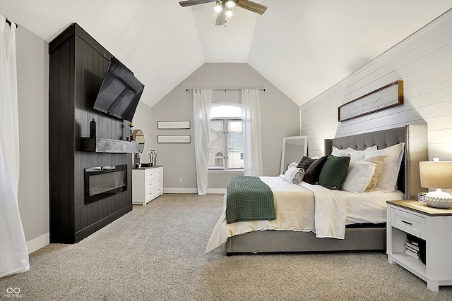 carpeted bedroom with vaulted ceiling, ceiling fan, and a fireplace