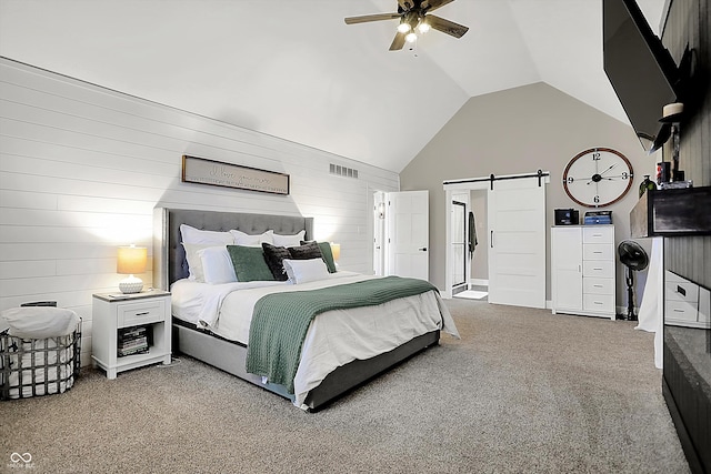 carpeted bedroom with a barn door, high vaulted ceiling, and ceiling fan