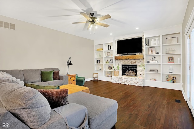 living room with ceiling fan, hardwood / wood-style floors, built in features, and a fireplace