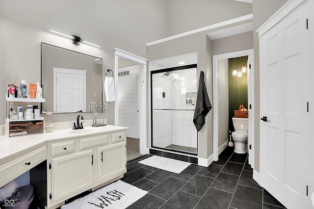 bathroom featuring tile patterned flooring, vanity, toilet, and a shower with shower door