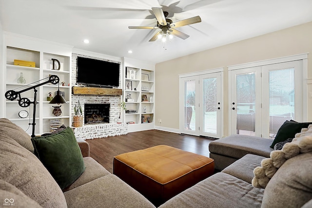 living room featuring hardwood / wood-style flooring, ceiling fan, a fireplace, and built in features