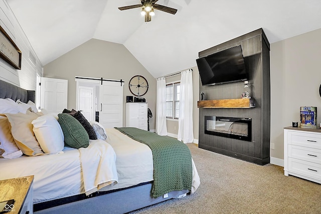 carpeted bedroom featuring ceiling fan, a large fireplace, a barn door, and vaulted ceiling